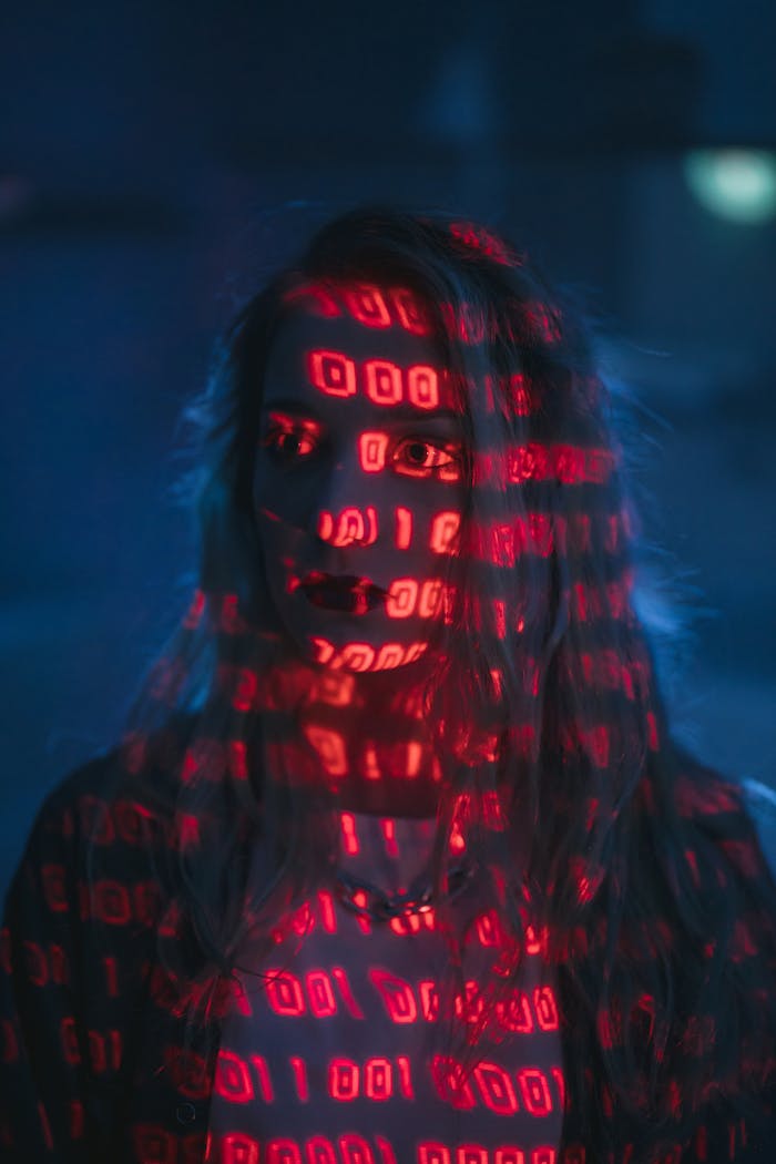 service-03 A woman with red binary code projected on her face, signifying technology and cybersecurity.